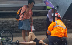 单车男青山公路捱的士撞受伤倒地 好心途人撑伞挡雨