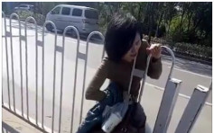 北京女疑贪快穿过路边栏杆被卡住　来回移动难脱身