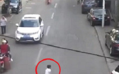 重庆两名男童玩命乱过马路 第3次被卷入车底