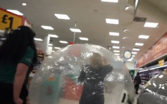 恐懼感染新冠病毒 英國大媽躲進充氣球一路滾進超市