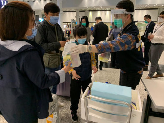 港人到达香港机场后，入境处职员为他们派发由航空公司提供的食物包。读者提供