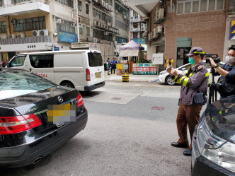 交通督导员在长沙湾青山道与通州西街交界执勤，向传媒示范发出电子告票的行动。