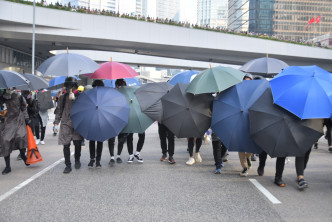 金钟一批示威者在场张开雨伞与警方对峙。