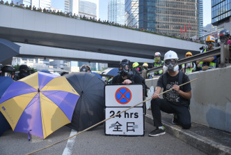 金钟一批示威者在场张开雨伞与警方对峙。