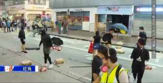 示威者破壞商店木板並堵路。NOW新聞截圖