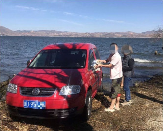张男自驾至大理游玩时在大理洱海边洗车相被人拍下放上网。