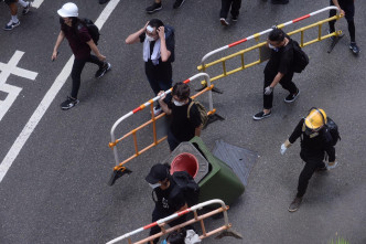 示威者帶同鐵馬及垃圾桶移動。