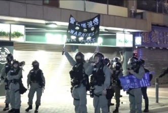 防暴警察展示黑旗。港台电视截图