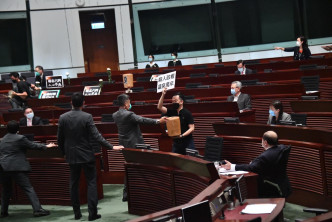 朱凯廸和陈志全在议事厅洒有机肥料。