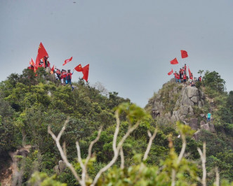 市民持旗登山，在山頂揮舞國旗及香港區旗。