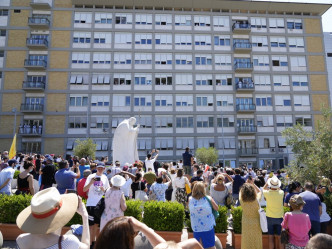 教宗方济各向聚集医院外的民众挥手。AP图片