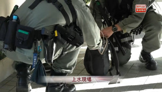 防暴警察搜查示威者随身背包。港台截图