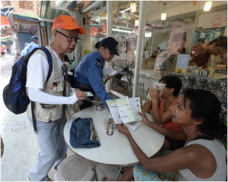民安隊員及地區人士向居民及遊人派滅蚊宣傳單。