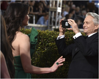 米高德格拉斯拿起手機幫為靚老婆嘉芙蓮影相。AP