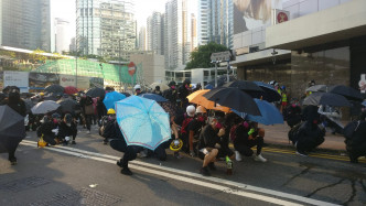 金鐘一批示威者在場張開雨傘與警方對峙。