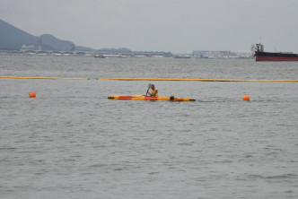 救生员爬独木舟到防鲨网附近劝喻泳客上水。 梁国峰摄