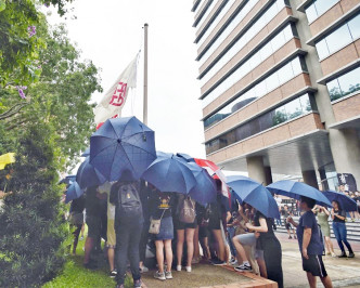 开雨伞的部分集会人士将理大旗帜降下换上黑旗。