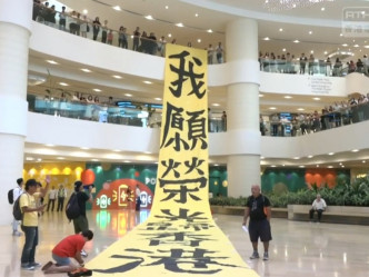 反修例示威者將「我願榮光歸香港」的巨型直幡掛上商場。港台截圖