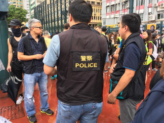現場有穿著警察背心的人士，準備跟遊行糾察簡介及點人數。