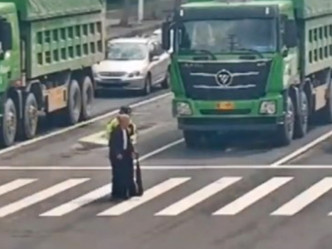 宁波公安交警大队铁骑中队辅警发现老人走回来，于是上前搀扶老人过了马路。网图