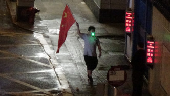 有人手持中國國旗。
