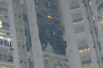 起火單位嚴重焚毀，連同樓上兩層樓的外牆被熏黑。