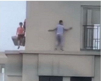 3童爬出栏杆，沿著顶楼外墙游走玩耍。网图