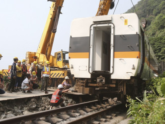 台鐵正利用吊車逐一將出軌車廂吊走。AP　