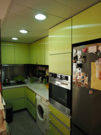 厨房采用半开放式设计，设有组合厨柜，以青绿色为主调。