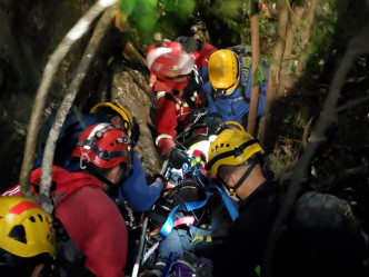 消防人員在發生小型山泥傾瀉後，將女傷者緊急撤離至飛行服務隊吊運點。消防處提供