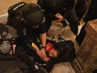 現場警員為中槍的女示威者進行急救。