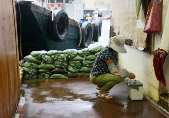 風暴期間，有居近海市民在擺放沙包等防水浸。