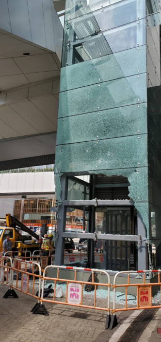 夏𢡱道通往立法會大樓的行人天橋電梯，有玻璃外牆被打爆碎裂。 楊偉亨攝