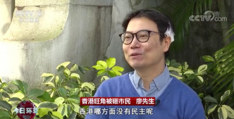 清理旺角路障被示威者用坑渠盖袭击头部的男子。央视新闻截图