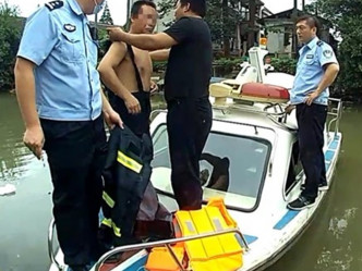 当地警员派小艇到河道，将男子带上船。网图
