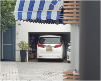 香岛道34号其中一幢独立屋外，停泊一辆挂有中港车牌的七人车。