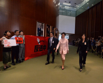 民主派在会议厅外拉起一幅写有「反送中」的红色大型横额。