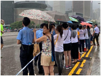 市民為警撐傘。