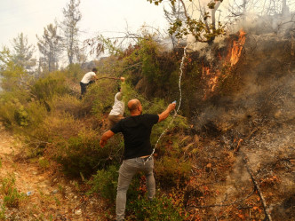 有市民協助撲救山火。REUTERS