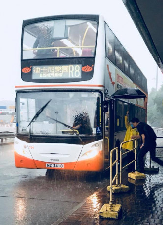 姨姨巴士站头为乘客挡雨，感动网民获赞有爱。网上图片