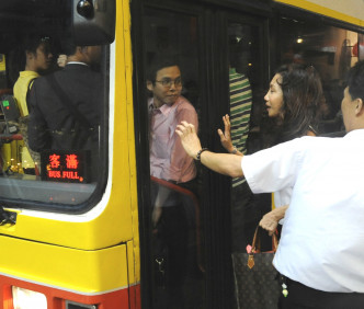 繁忙时间经常出现巴士乘客企到车门。资料图片