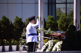 盧偉聰向殉職警員姓名的紀念冊獻上花圈。