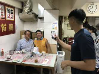 陳茂波(左一)到訪茶餐廳與市民聊天。網誌圖片