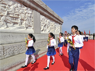 有手持鮮花的少年兒童面向人民英雄紀念碑致敬。新華社圖片