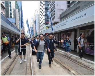 香港众志成员冲出电车轨。