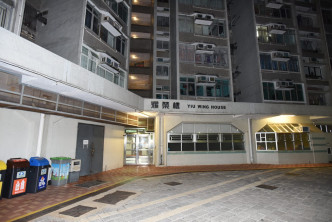 關員將其中一名疑犯押返耀安邨耀榮樓一單位搜查。