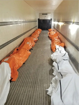 纽约有一名护士，拍下医院门口一辆冷藏货柜车，里面排列塞满两排的尸袋。(Twitter图片)