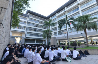 学生在校门的喇沙像前静坐。