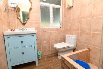 图中浴室用橙色墙身，配上蓝色收纳柜，极富特色。