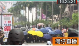 示威者打开雨伞阻挡。有线新闻截图